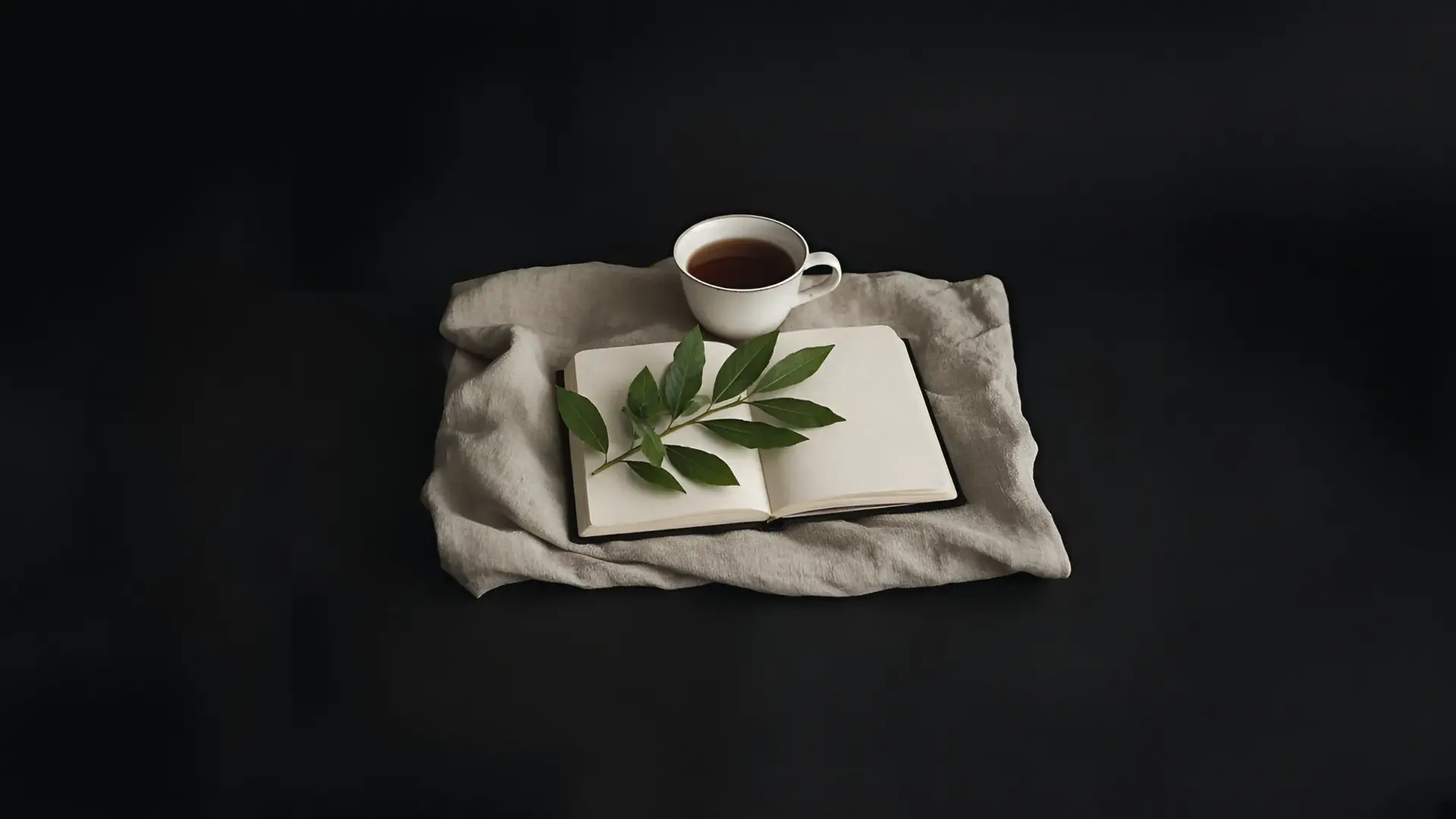 An open book of verse beside a laurel sprig and a cup of tea on linen, for a guide to Anne Carson books
